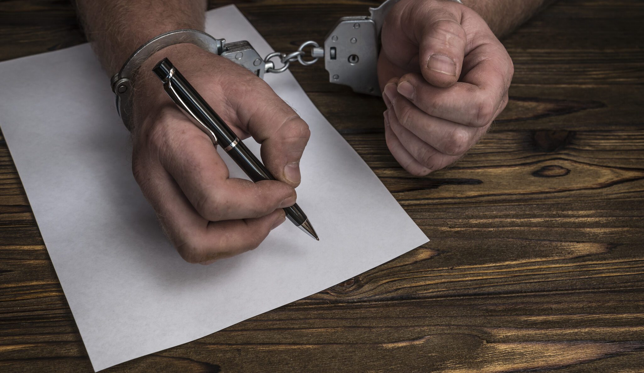 hand holding a pen crossing off a police report
