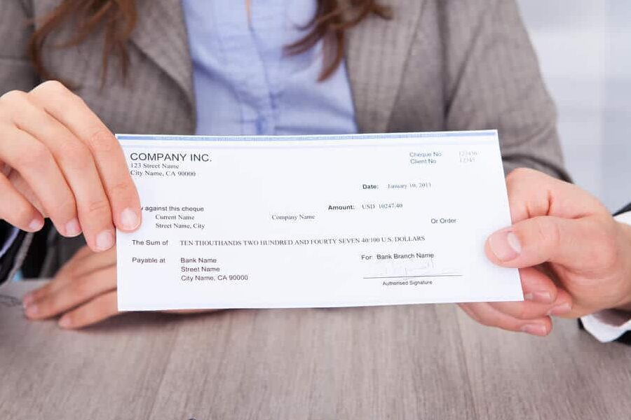 happy person receiving a check from the bank