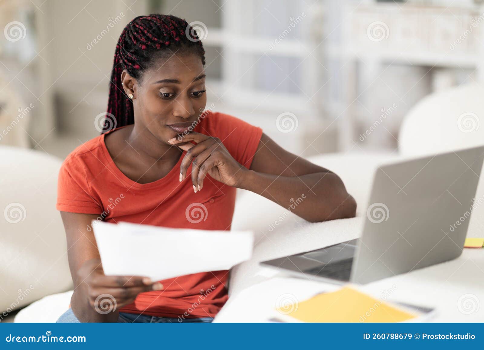 Mujer revisando documentos financieros en casa