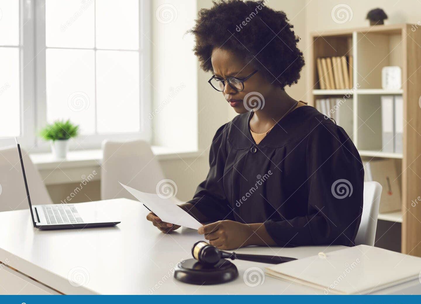 un hombre leyendo documentos legales y frunciendo el ceno